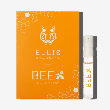 Petit flacon de parfum Bee 1,5 ml à côté de la carte porte-flacon Bee Eau de Parfum orange.