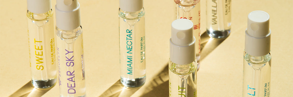 Dear Sky Eau De Parfum 1.5ml Vial, Miami Nectar Eau De Parfum 1.5ml Vial, Apple Love Eau De Parfum 1.5ml Vial, Salt Eau De Parfum 1.5ml Vial, Sun Fruit Eau De Parfum 1.5ml Vial, Florist Eau De Parfum 1.5ml Vial, Sweet Eau De Parfum 1.5ml Vial, and Vanilla Milk Eau De Parfum 1.5ml Vial, on yellow background.