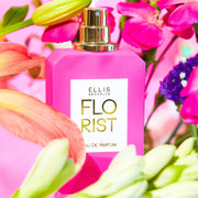 Florist 50 ml Eau de Parfum sur un fond rose entouré de fleurs roses, vertes, jaunes, orange et violettes.