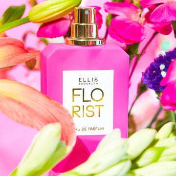 Florist 50 ml Eau de Parfum sur un fond rose entouré de fleurs roses, vertes, jaunes, orange et violettes.