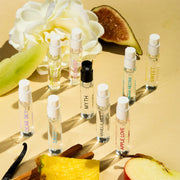Dear Sky Eau de Parfum 1,5 ml fiole, Miami Nectar Eau de Parfum 1,5 ml fiole, Apple Love Eau de Parfum 1,5 ml fiole, Salt Eau de Parfum 1,5 ml fiole, Sun Fruit Eau de Parfum 1,5 ml fiole, Florist Eau de Parfum 1,5 ml fiole, Myth Eau de Parfum 1,5 ml fiole, Sweet Eau de Parfum 1,5 ml fiole, et Vanilla Milk Eau de Parfum 1,5 ml fiole, sur fond jaune avec figue, fleur blanche, melon, gousse de vanille, bois de santal, ananas, et pomme.