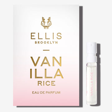 Échantillon d'eau de parfum VANILLA RICE (1,5 ml) à côté de son carton de présentation (dégradé de blanc et de rose) sur fond blanc.